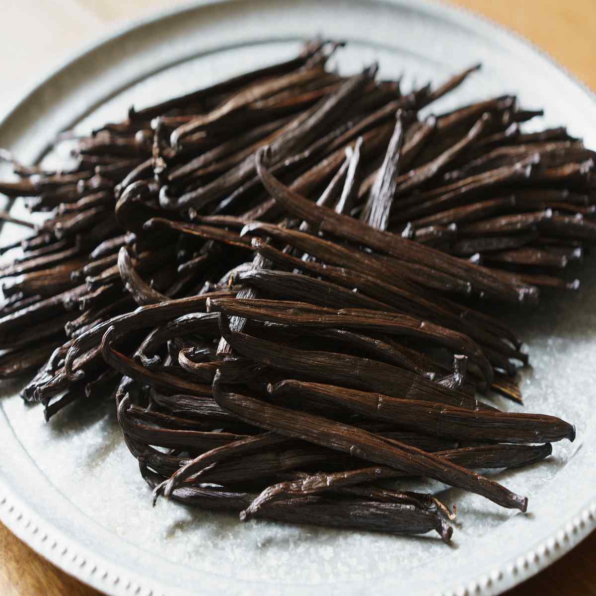 Premium vanilla beans stacked on a plate for baking, desserts, and gourmet extract production