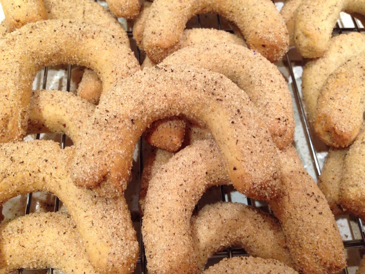 Vanilla crescent cookies dusted with vanilla sugar on a cooling rack