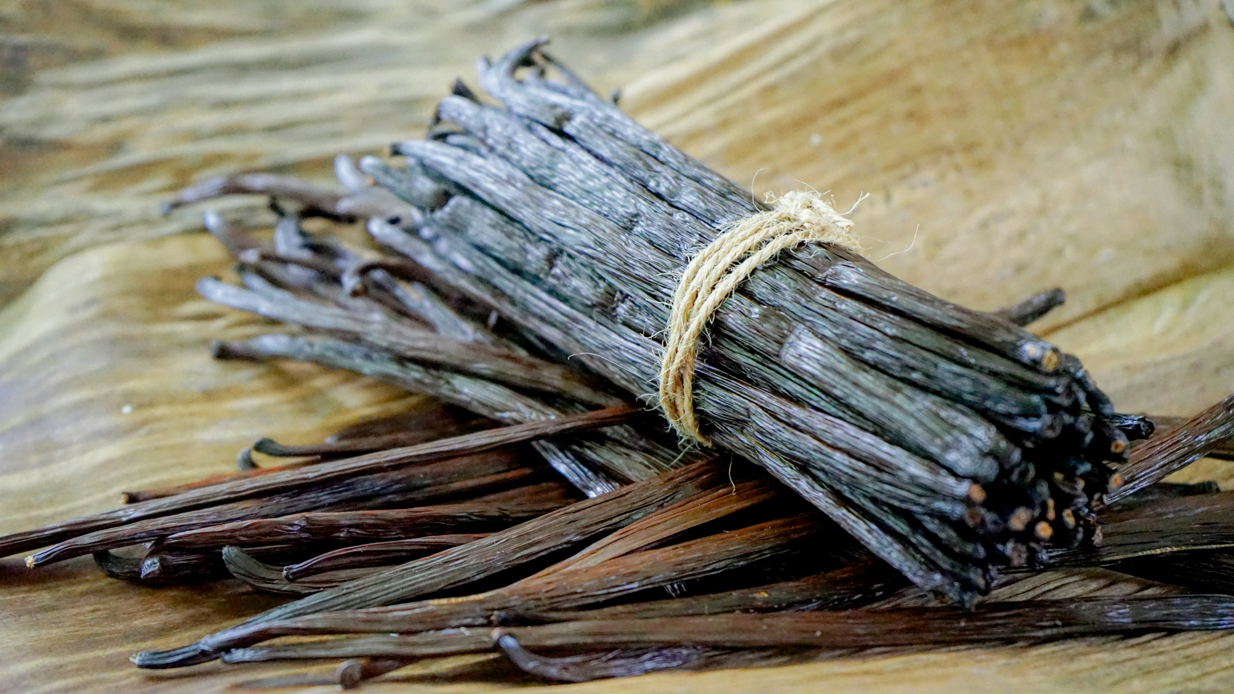 A bundle of vanilla beans on a wooden table